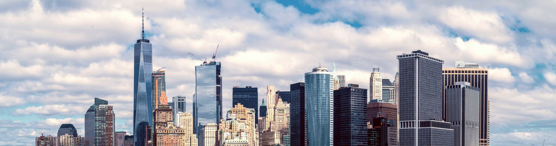 The Lower Manhattan skyline and Battery Park across the harbor on a bright day